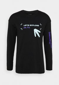 Svart långärmad t-shirt med blå och lila text och mönster. Har "LÅT OSS UTFORSKA" fram och "DRÖM DET." på ärmen. Mjuk tyg.