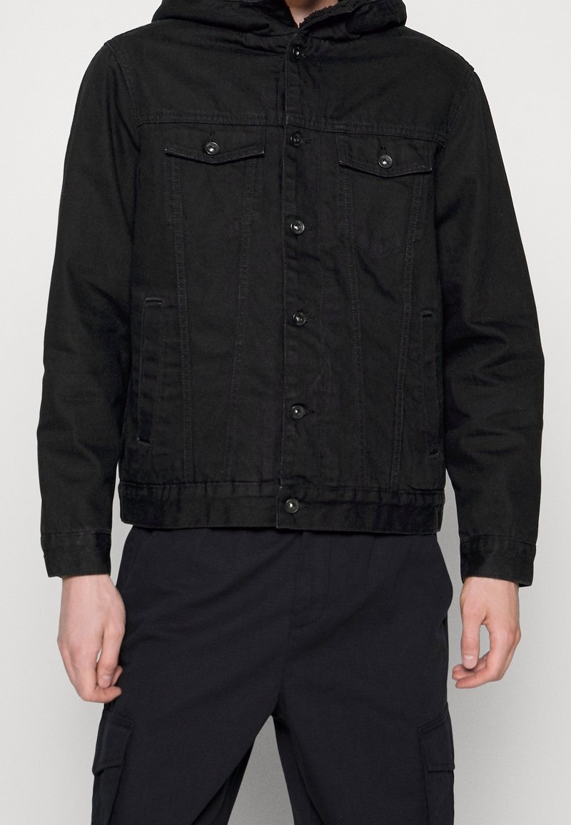 Czarna kurtka dżinsowa z kapturem, zapinana na guziki z przodu, z dwoma kieszeniami na piersi i bocznymi. Wykonana z teksturowanego materiału, o dopasowanym kroju.