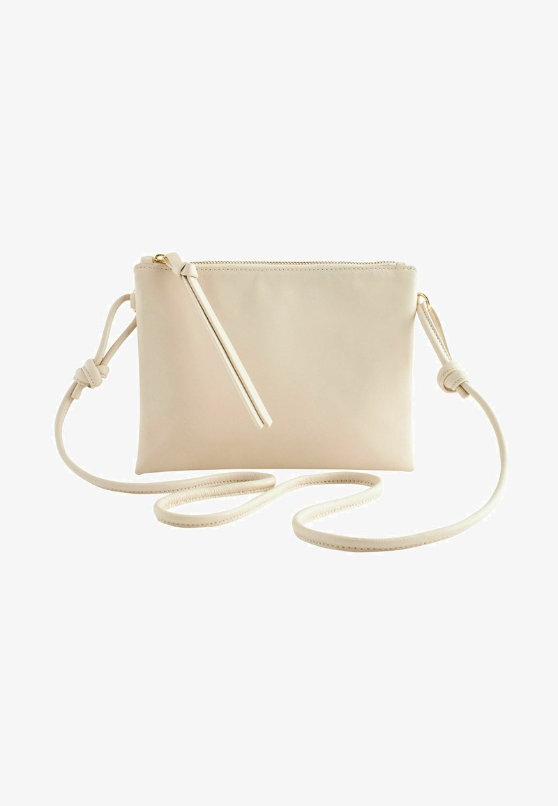 Light beige leather crossbody bag with a smooth texture, zip closure, and an adjustable strap featuring a knotted detail.