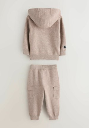 Beige knit hoodie with hood and ribbed cuffs, paired with matching joggers featuring side pockets and elastic waistband.
