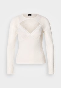 Λευκή μακρυμάνικη μπλούζα από δαντέλα με V-λαιμόκοψη και λεπτή δαντέλα κατά μήκος του λαιμού. Διαθέτει κούμπωμα με κουμπιά στον γιακά.