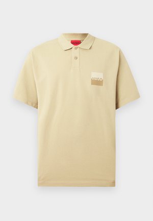 Polo shirt beige in cotone, con colletto a tre bottoni, maniche corte e una toppa con logo in crema e marrone sul petto sinistro.