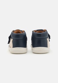 Navy Leder High-Top-Schuhe mit einem hellbraunen Akzent, Klettverschluss und strukturiertem weißen Gummisohle. Weicher, gefütterter Innenbereich für Komfort.