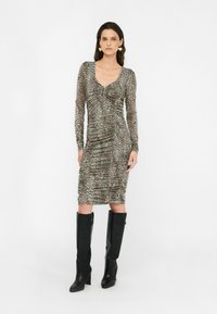 Rochie cu imprimeu leopard, cu detalii plisează, mâneci lungi și decolteu rotund, asortată cu cizme negre cu toc până la genunchi.