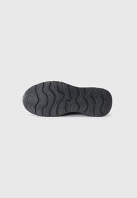 Semelle de chaussure en caoutchouc noir avec un motif de bande de roulement ondulé pour une meilleure traction. Matériau durable, design plat et surface texturée pour une bonne adhérence.