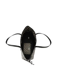 Borsa a spalla a modello a righe in bianco e nero con due lunghe cinghie piatte. L'interno presenta una tasca con zip e un motivo coordinato.