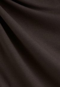 Brunt stof med en glat tekstur, der viser fald og en subtil glans. Materialet virker blødt og strækbart, egnet til forskellige anvendelser.
