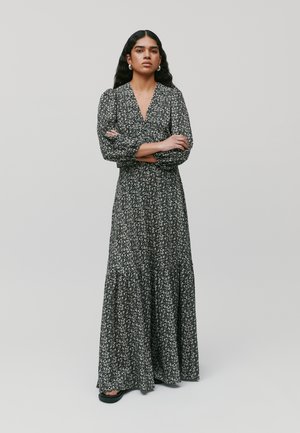 Zwarte bloemen maxi-jurkje met lange pofmouwen, V-hals en gerimpelde zoom. Gemaakt van lichte stof met een delicate print.