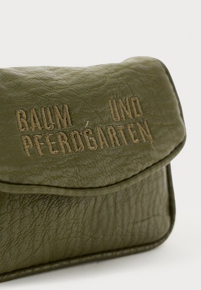 Alyvuogių žalios odos delninė su įspaustu tekstu "BAUM UND PFERDGARTEN." Turime tekstūruotą paviršių ir kreivinį užsegimą.