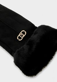 Bufanda de pelaje sintético negra con un acabado textil suave, borde plegado y un detalle de hardware en tono dorado con un diseño entrelazado.