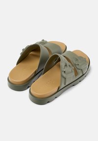 Green rubber slide sandals with two wide straps, featuring a textured surface and engraved brand name on the insole.