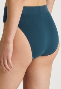 High-waisted teal underwear made of smooth fabric, featuring a seamless design and no visible hardware or patterns.