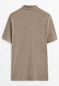 Polo shirt à manches courtes de couleur marron, en tissu doux, présentant un col classique, une texture subtile et des coutures contrastées le long de l'encolure.