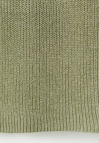 Gros plan d'un tissu tricoté vert olive avec une texture côtelée verticale et un motif de points serré et uniforme.