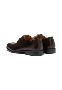 Pantofi de costum din piele maro cu un finisaj neted, vârful rotund și toc mic. Dispun de șireturi și un design simplu, curat.