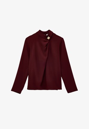 Bordowa bluzka z długim rękawem o wysokim dekolcie, z marszczonym przodem i małą ozdobną złotą klamrą na kołnierzyku.