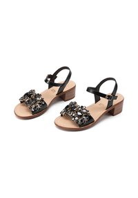 Sandali in pelle nera con tacco in legno basso, caratterizzati da un'ornamentazione decorativa in perline sulla punta e una cintura alla caviglia regolabile.
