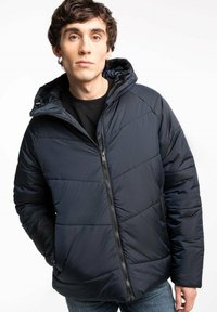 Granatowa kurtka puchowa z kapturem, zapinana na zamek, o pikowanej fakturze. Posiada elastyczne mankiety, boczne kieszenie oraz gładkie wykończenie.
