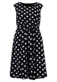 Vestido negro sin mangas con lunares blancos, con un corpiño ajustado y un cinturón anudado en la cintura, que presenta una silueta de falda acampanada.