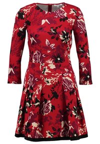 Robe rouge à fleurs avec manches longues, dotée d'un corsage ajusté et d'une jupe évasée. Motifs floraux en noir et crème. Comprend une fermeture éclair au dos.