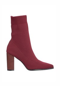 Botín burdeos de caña corta hecho de material de punto elástico, con punta puntiaguda y tacón bloque sólido. Borde superior acanalado para mayor textura.