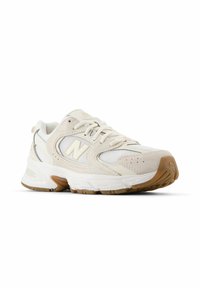 Helle beigem Sneaker aus Mesh- und Wildledermaterialien, mit Schnürsenkeln, gepolstertem Kragen, Gummisohle und einem weißen Logoakzent an der Seite.