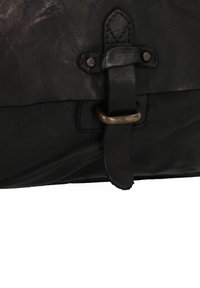 Borsa in pelle nera con finitura testurizzata, dotata di una tracolla in pelle e chiusura con anello metallico, e dettagli di cucitura visibili.