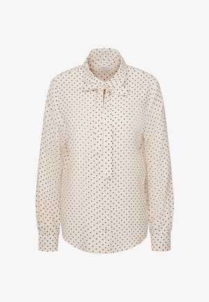 Cremfarbige Bluse mit langen Ärmeln und schwarzen Punkten, knöpfbare Vorderseite, geknöpfte Ärmel und eine Schleife am Kragen.