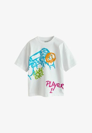 T-shirt blanc à manches courtes avec une manette de jeu vidéo bleue, un visage souriant orange, un texte vert « Game Over » et un texte rose « Player 1 ».