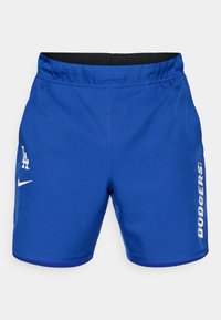 Siniset urheilushortsit, jotka on valmistettu sileästä kankaasta. Shortsien vyötäröllä on joustava vyö, ja niissä on valkoinen Nike-logo sekä "DODGERS" painettuna pystysuoraan valkoisena.