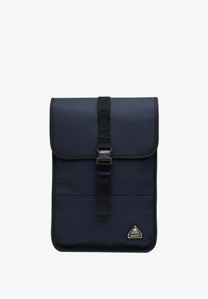 Veske i marineblått med klafflukking, laget av teksturert stoff. Har en sentral stropp med spenn og et trekantet logo-patch.