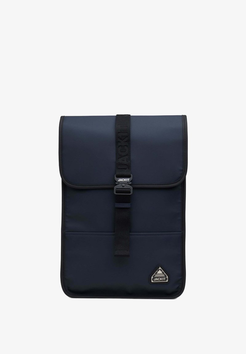 Granatowy plecak z klapą, wykonany z teksturowanej tkaniny. Posiada centralny pasek z zapięciem oraz trójkątną naszywkę z logo.