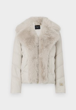 Hellbeige gesteppte Jacke mit großem flauschigem Kragen, vorderen Taschen, Reißverschluss und Logopatch am linken Ärmelbündchen.
