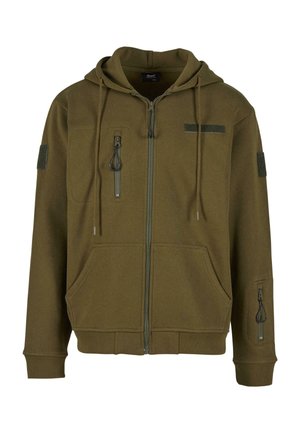 Olijfgroene hoodie met een rits aan de voorkant, twee voorkezen en een ritszak op de mouw. Bevat stoffen patches.