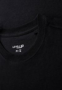 Černé tričko s kulatým výstřihem, žebrovaným límcem a štítkem s označením velikosti M (EUR 48) a názvem značky "LEVEL UP". Měkká bavlněná tkanina.