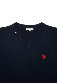 Navyblauwe V-hals trui met een geribbelde textuur, voorzien van een rood geborduurd polo-logo op de borst en een kleine driekleurige accent nabij de kraag.