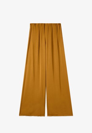 Leveälahkeiset, sinapinväriset housut, joissa on joustava vyötärönauha, sileä kangas ja hienovaraiset laskokset yläosassa.