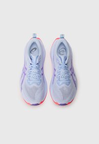 Zapatillas de running de color púrpura claro con parte superior de malla, cordones en contraste y suela acolchada. Presentan una suela rosa y acentos morados.