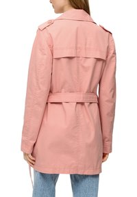 Lichtroze trenchcoat van katoen. Voorzien van een belted taille, schouderepauletten en een achterflap. Lange mouwen en een ontspannen pasvorm.