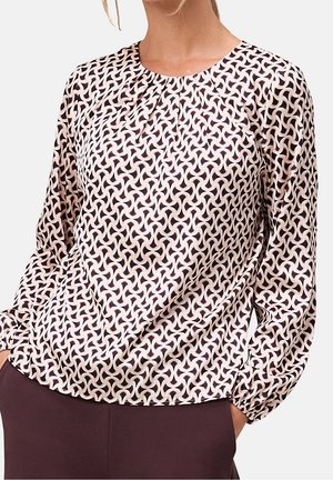 Blouse à manches longues en tissu léger avec un motif géométrique bordeaux et crème, encolure ronde et détails froncés aux épaules.