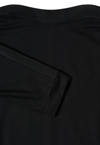 Musta pitkähihainen paita, jossa on sileä kangas, taitettu hiha ja hienovarainen rakenteellinen nauhadetus hihassa ja kaula-aukkossa.