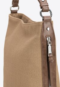 Brązowa torebka z teksturowanej tkaniny z brązowym skórzanym uchwytem i srebrnymi detalami na zamku błyskawicznym. Posiada strukturalny kształt oraz regulowany pasek na ramię.