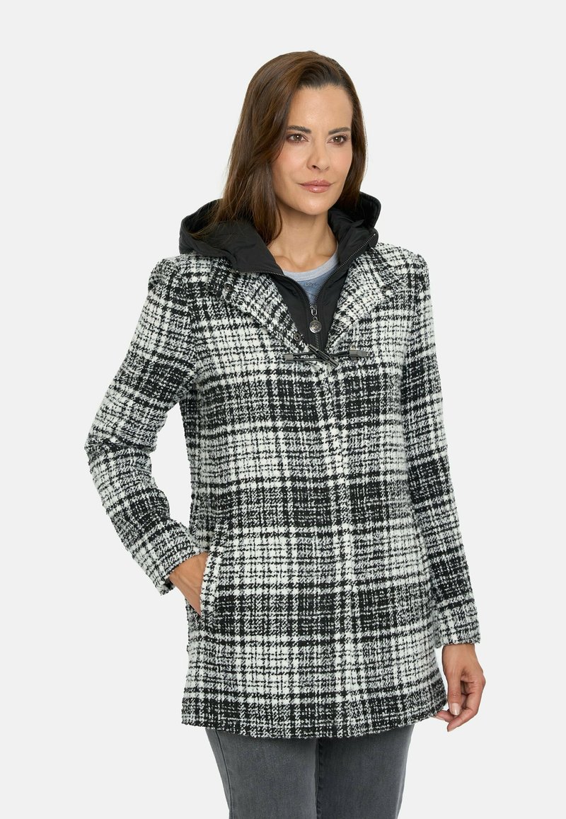 Abrigo de cuadros en blanco y negro con capucha. Presenta mangas largas, tejido texturizado y bolsillos laterales. Cierre de cremallera con herrajes plateados.