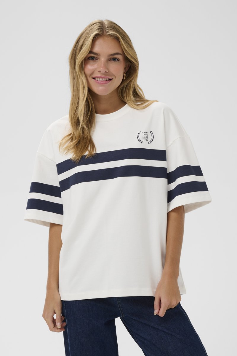 Biela bavlnená tričko s námorníckymi horizontálnymi pruhmi, voľný strih, okrúhly výstrih a malým grafickým logom na ľavej hrudi.