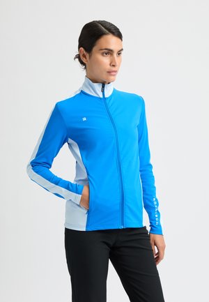 Giacca sportiva blu con colletto alto, chiusura con zip e pannelli laterali azzurri a contrasto. Presenta un logo sul lato sinistro del petto e della manica.