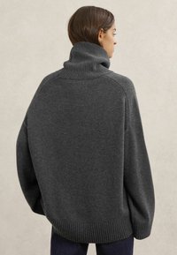 Oversized trui in houtskoolgrijs met een hoge geribbelde kraag, verlaagde schoudernaden en geribbelde zoom. Zachte textuur, casual pasvorm.