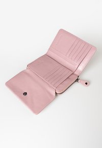 Roze leren portemonnee met een ritssluiting, meerdere kaartsleuven en een insteekvak. Gladde textuur en minimalistisch ontwerp. Onbevoegd voor zichtbaarheid.