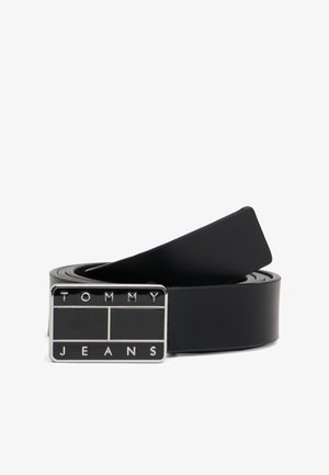 Cintura in pelle nera con fibbia rettangolare d'argento con inciso "TOMMY" e "JEANS" in lettere maiuscole. Texture liscia e design classico.