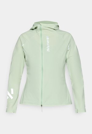 Lichtgroene, getailleerde jas van ademend materiaal. Voorzien van een volledige ritssluiting, capuchon en reflecterende witte accenten op de mouwen en borst.