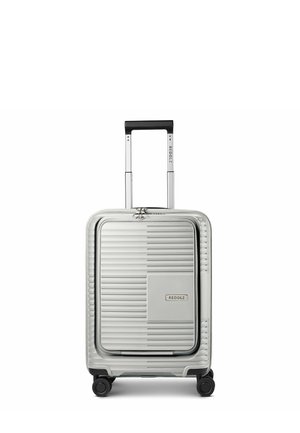 Silver hard-shell suitcase with front pocket, telescopic handle, four wheels, and brand name "REDOLZ" on front and handle.